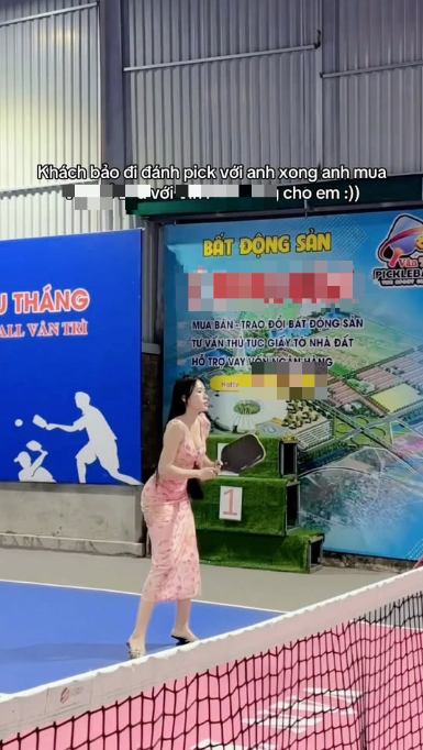 Cô gái mặc váy hồng cầm vợt Pickleball